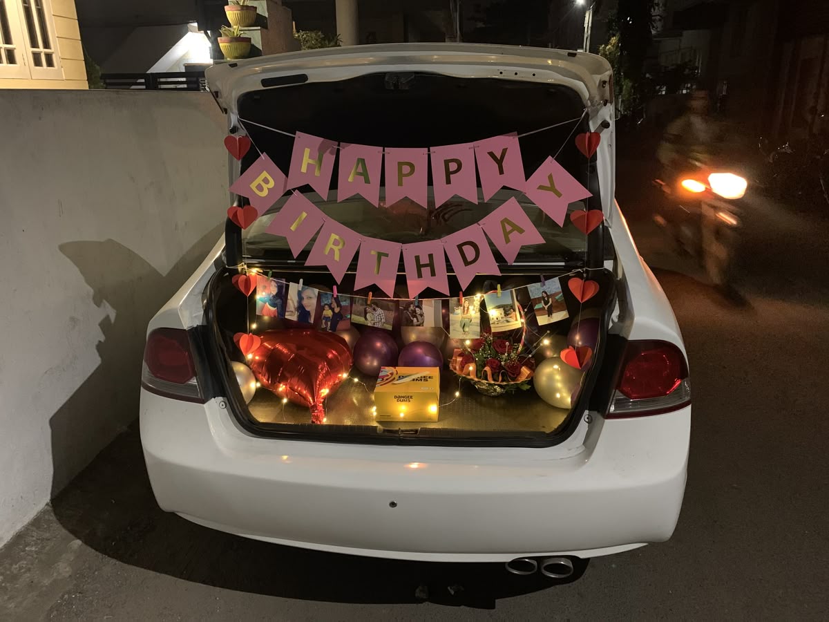 Car trunk surprise with pink banner and photo string