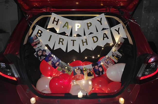 Red car trunk surprise with photos and balloons